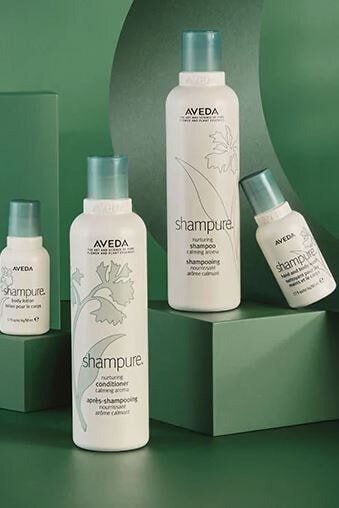 Aveda Shampure Nurturing Shampoo and Conditioner on soft green pedestals